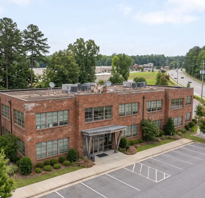 Brick commercial building with an aging flat roof and rooftop units